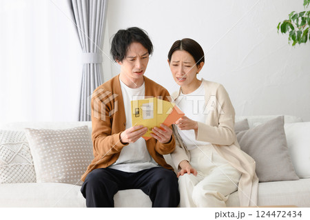 督促状を見て困る男女 124472434