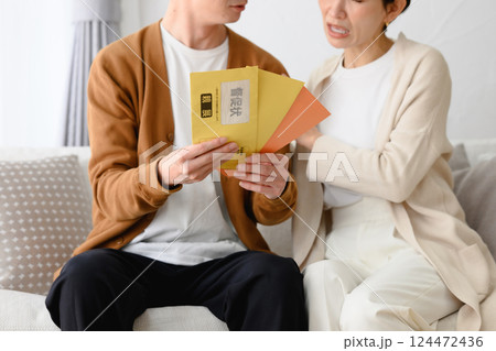 督促状を見て困る男女 督促状を見て困る男女 124472436
