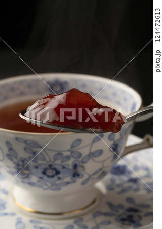 ロシアンティー スプーンに乗せたジャムを熱々の紅茶に入れる ロシアンティー スプーンに乗せたジャムを熱々の紅茶に入れる 124472613