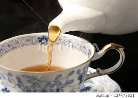 ティーポットでティーカップに紅茶を注ぐ ティーポットでティーカップに紅茶を注ぐ 124472621