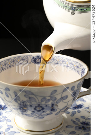 ティーポットでティーカップに紅茶を注ぐ 124472624