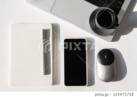 Tech Professional Setup. Overhead Shot of Laptop, Phone, Mouse and Notebook on Sleek Desk. Tech Professional Setup. Overhead Shot of Laptop, Phone, Mouse and Notebook on Sleek Desk. 124473738