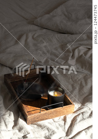 Burning Incense Stick and Illuminated Candle on Wooden Tray Create Tranquil Atmosphere for Meditation. Burning Incense Stick and Illuminated Candle on Wooden Tray Create Tranquil Atmosphere for Meditation. 124473745