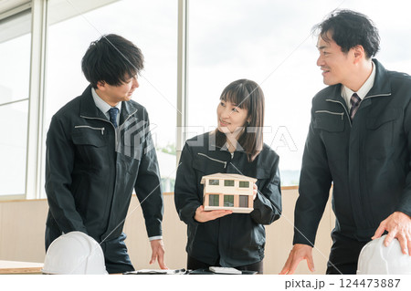 住宅模型を持つハウスメーカー・住宅メーカー・工務店の男女ビジネスマン 124473887