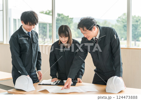 打ち合わせ,ミーティングをする作業着姿の建設業,建築業の男女のビジネスマン 124473888