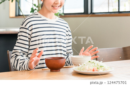 ダイニングテーブルで食事する小学生,中学生の女の子 124475701