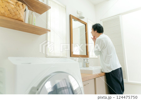 鏡を見てスキンケアをする若い男性 鏡を見てスキンケアをする若い男性 124475750