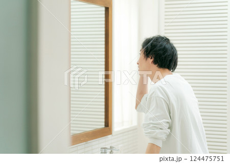 鏡を見てスキンケアをする若い男性 鏡を見てスキンケアをする若い男性 124475751