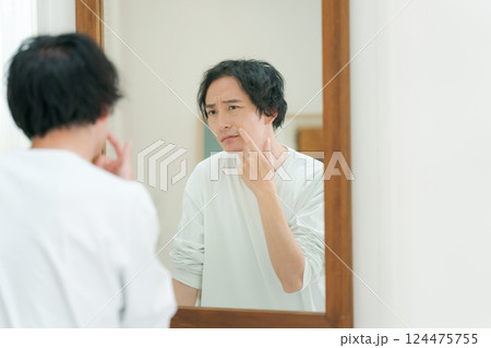 鏡を見てスキンケアをする若い男性 鏡を見てスキンケアをする若い男性 124475755