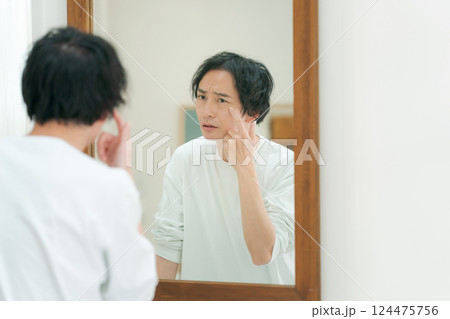鏡を見てスキンケアをする若い男性 124475756