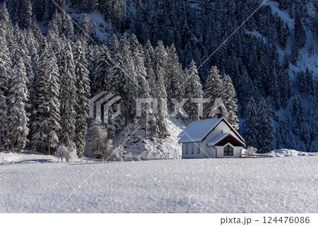 Winter landscape on a sunny day in December with a minimalist snow-covered church Winter landscape on a sunny day in December with a minimalist snow-covered church 124476086