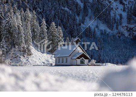 Winter landscape with a church in deep snow nature in the Bavarian Alps, Germany 124476113
