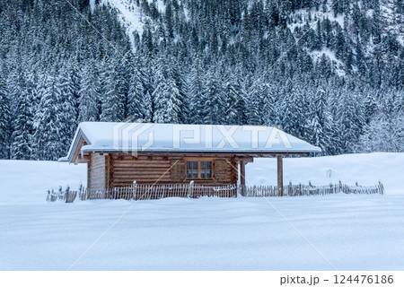 Snow-covered log cabin in deep snow landscape in Bavaria, Germany 124476186