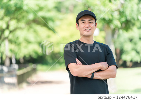 新緑の公園でスポーツウェアを着て腕組みをするアジア人男性 124476417