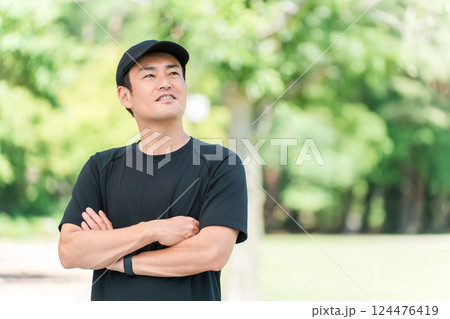 新緑の公園でスポーツウェアを着て腕組みをするアジア人男性 124476419