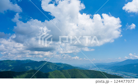 青空に流れるたくさんの白い雲と、緑に包まれた山々 青空に流れるたくさんの白い雲と、緑に包まれた山々 124477077