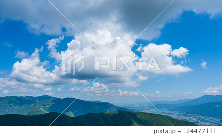青空に流れるたくさんの白い雲と、緑に包まれた山々 青空に流れるたくさんの白い雲と、緑に包まれた山々 124477111