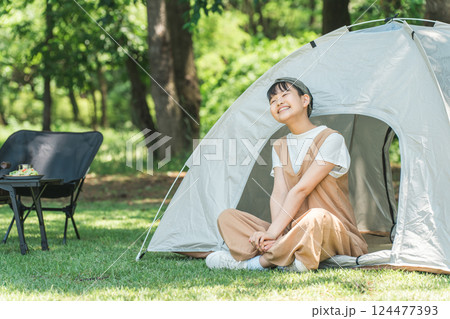 キャンプ場でテントの中でくつろぐ女の子 124477393