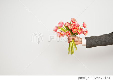 Romantic man presents a bouquet of tulips Romantic man presents a bouquet of tulips 124479123