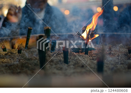 線香の炎と煙に包まれる祈りのひととき 124480608