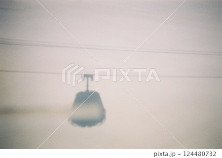 雪の中に浮かぶロープウェイのシルエット 124480732