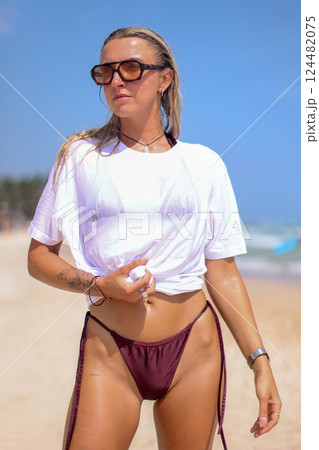 A Stylish Photo of Trendy Beachwear Showcasing a Beautiful Model Posing on the Shoreline A Stylish Photo of Trendy Beachwear Showcasing a Beautiful Model Posing on the Shoreline 124482075