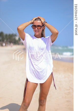 A Stylish Photo of Trendy Beachwear Showcasing a Beautiful Model Posing on the Shoreline 124482081