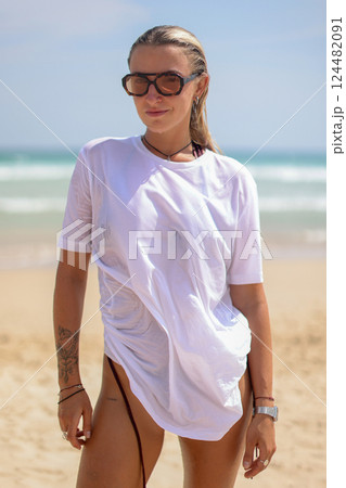 A Stylish Photo of Trendy Beachwear Showcasing a Beautiful Model Posing on the Shoreline A Stylish Photo of Trendy Beachwear Showcasing a Beautiful Model Posing on the Shoreline 124482091