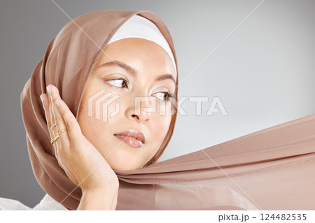 Face, makeup and beauty cosmetics of muslim woman isolated against gray studio background. Skincare, spa facial or female model from Turkey with glowing, beautiful flawless skin and traditional hijab 124482535