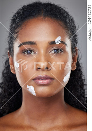 Beauty, face and skincare cream with black woman in a studio for wellness, grooming and hygiene against grey background. Portrait, model and sunscreen product for cosmetic, dermatology and facial 124482723