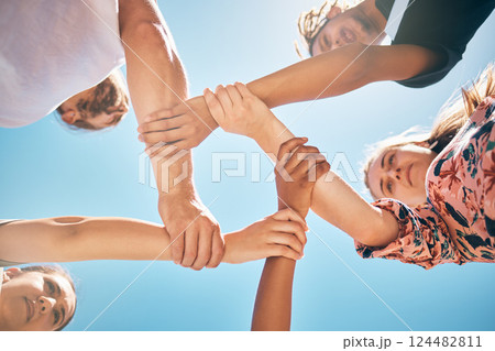 Support, holding wrists and friends in a circle for collaboration, trust and teamwork outdoors. Diversity, love and people in a community with compassion, respect and unity with a sky blue background 124482811