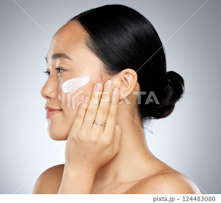 Beauty, skin and woman with face and cream, skincare and natural cosmetics advertising, facial product and treatment with grey studio background. Asian model, moisturizer and healthy body care. 124483080