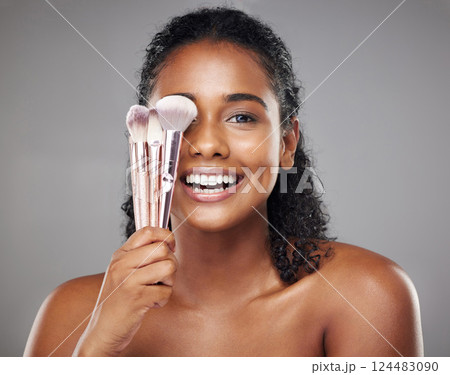 Makeup, beauty and portrait of woman with brush to apply foundation, skincare product or luxury facial cosmetics. Wellness, health and happy aesthetic face of model girl isolated on gray background Makeup, beauty and portrait of woman with brush to apply foundation, skincare product or luxury facial cosmetics. Wellness, health and happy aesthetic face of model girl isolated on gray background 124483090