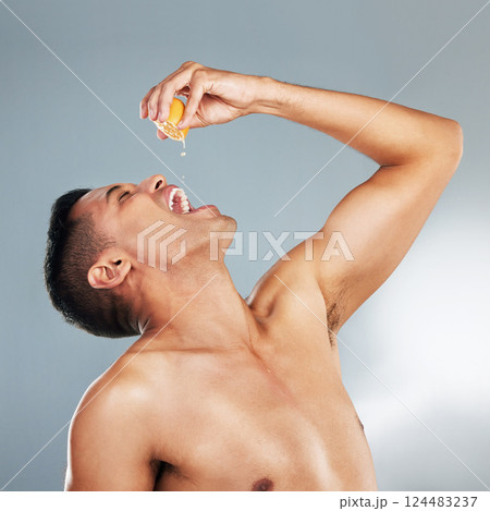Health, man and orange fruit for vitamin c for skincare, wellness and immune booster against grey background in studio. Male model, healthy cosmetics and natural beauty for dermatology advertisement 124483237