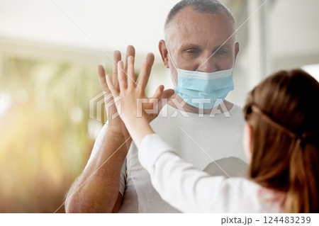 Covid, window and lockdown father with child for family hand touch with social distance protocol. Love, daughter and dad with quarantine mask protection at glass for communication with young kid. 124483239
