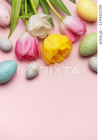 Colorful easter eggs and tulips creating festive border on pink background Colorful easter eggs and tulips creating festive border on pink background 124483290