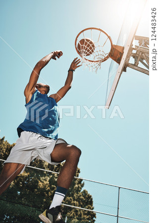 Basketball, sport and man with a goal during a game, professional event or training on an outdoor court in summer. Low view of an athlete in the air to score during sports for fitness and exercise Basketball, sport and man with a goal during a game, professional event or training on an outdoor court in summer. Low view of an athlete in the air to score during sports for fitness and exercise 124483426