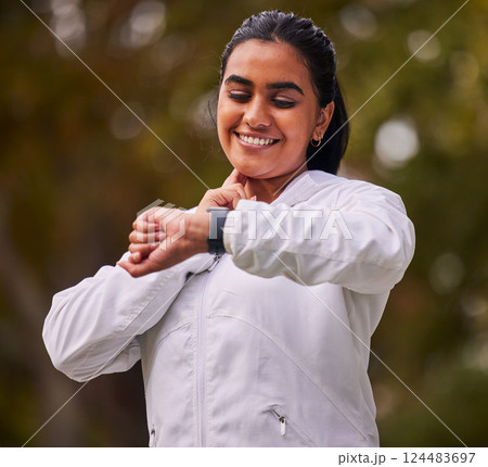 Pulse, fitness and woman running in the park, on a break to check heart rate on sports watch. Indian girl doing exercise, training and workout in nature for wellness, cardio and healthy lifestyle 124483697