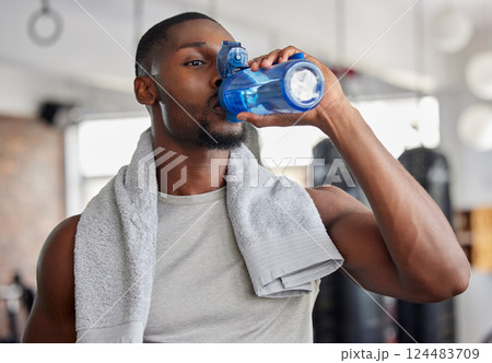 Water, drink and fitness with a sports man in a gym for exercise while taking a break to hydrate. Workout, training and drinking with a male athlete taking a sip from a bottle after his routine Water, drink and fitness with a sports man in a gym for exercise while taking a break to hydrate. Workout, training and drinking with a male athlete taking a sip from a bottle after his routine 124483709