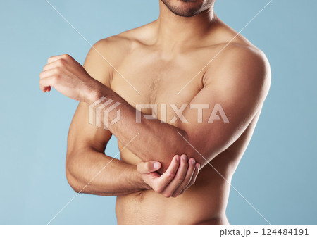 Fitness, man and elbow injury in studio for joint problem, workout accident and discomfort. Athlete, topless or arm muscle tension with inflammation, fibromyalgia and exercise pain on blue background 124484191