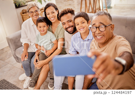Selfie, family and phone with grandfather taking a photograph of his grandchildren and their parents at home. Kids, photo and big family smile, happy and social media in living room with smartphone 124484197