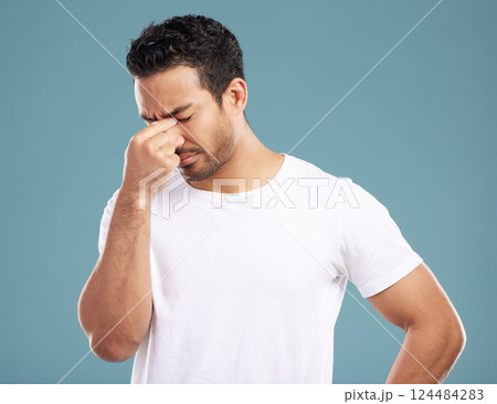 Headache, stress and man in studio with burnout, anxiety or frustrated by brain fog on blue background. Vertigo, person and male model exhausted for pain, migraine or tension and strain or fatigue 124484283