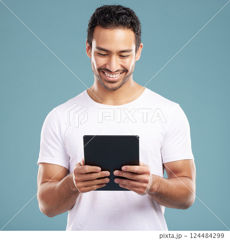 Studio, man and smile with tablet for social media, reading news and connection for communication. Happiness, male person and online with digital for post comment, blog website and blue background Studio, man and smile with tablet for social media, reading news and connection for communication. Happiness, male person and online with digital for post comment, blog website and blue background 124484299