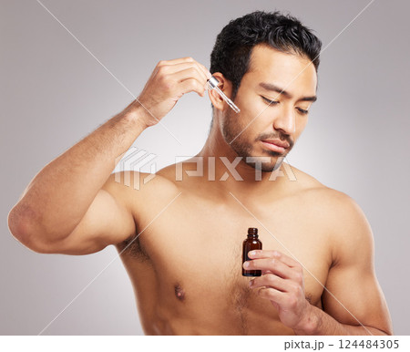 Skincare, man and serum oil in studio for skin hydration, anti aging treatment and collagen. Topless person, cosmetic dropper or dermatology product for natural face moisturizer on gray background 124484305