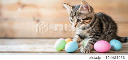 Curious kitten explores pastel colored eggs 124485058