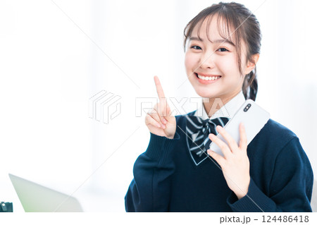 指差しポーズで微笑む女子高生 124486418