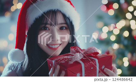 クリスマスプレゼントを持って笑顔の女性 124486642