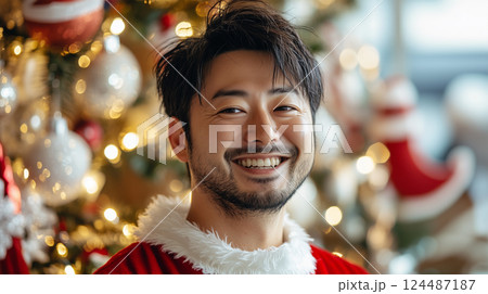 サンタ衣装で笑顔を見せる日本人男性とホリデーの光 サンタ衣装で笑顔を見せる日本人男性とホリデーの光 124487187
