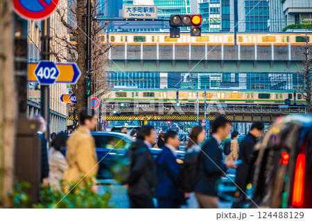 日本の東京都市景観 仕事帰り…大手町駅前の交差点や夕日を浴びる電車などを望む。奥は日本橋… 124488129