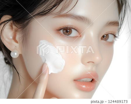 手の指で白い保湿クリームを顔に塗る女性（美容、スキンケア、化粧品、ビューティー、健康） 124489173